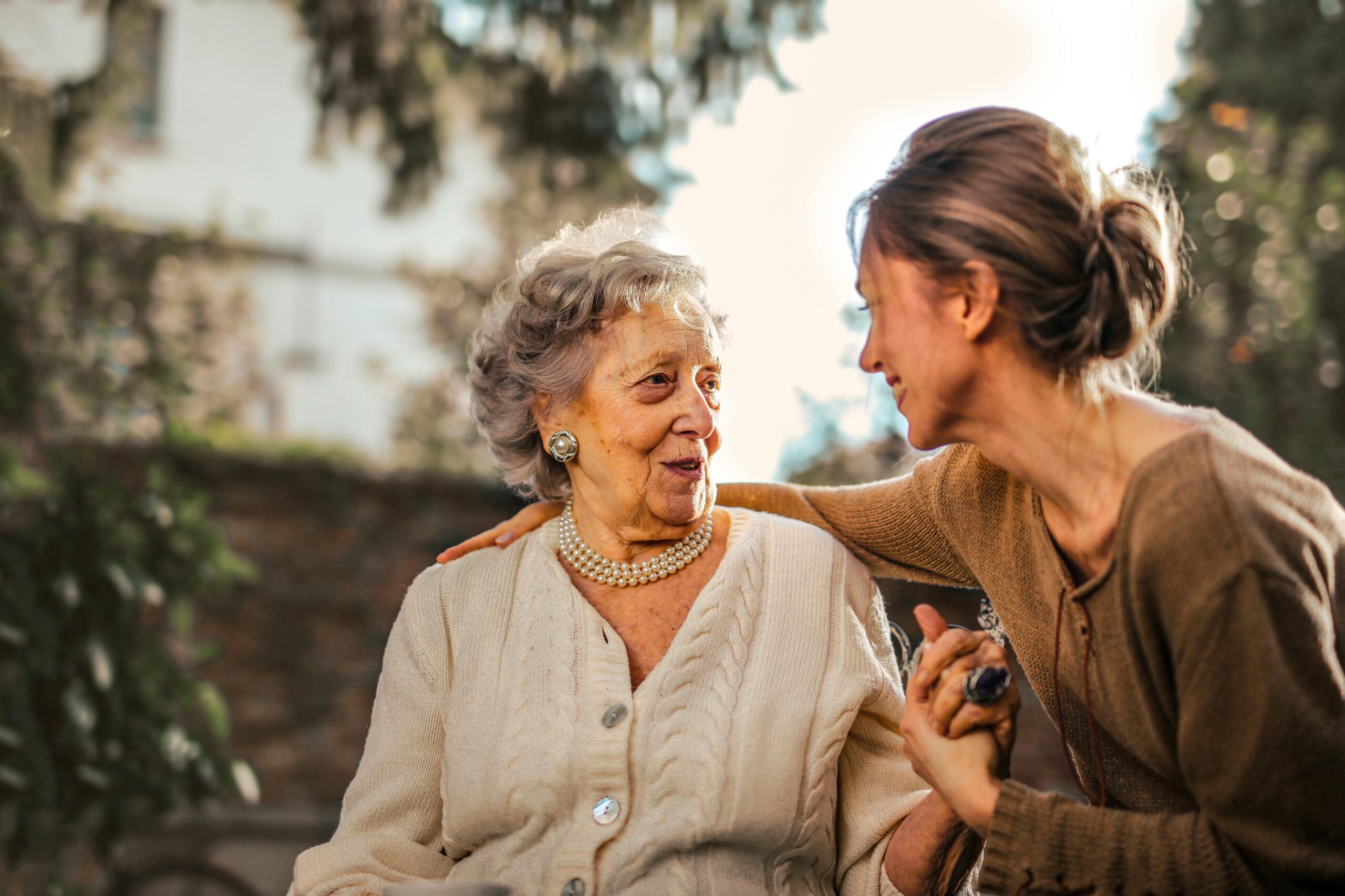 Person greeting an older woman making her happy by checking up on her