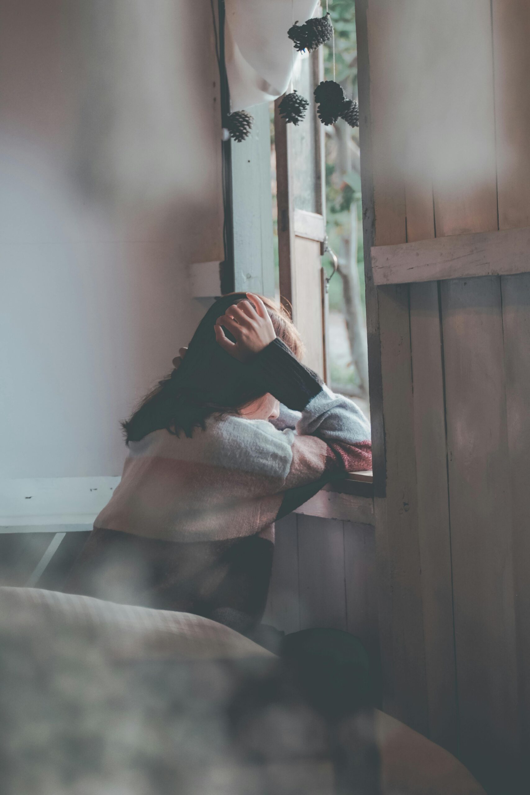 Person-looking-sad-at-windowsill-because-college-stress-and-anxiety