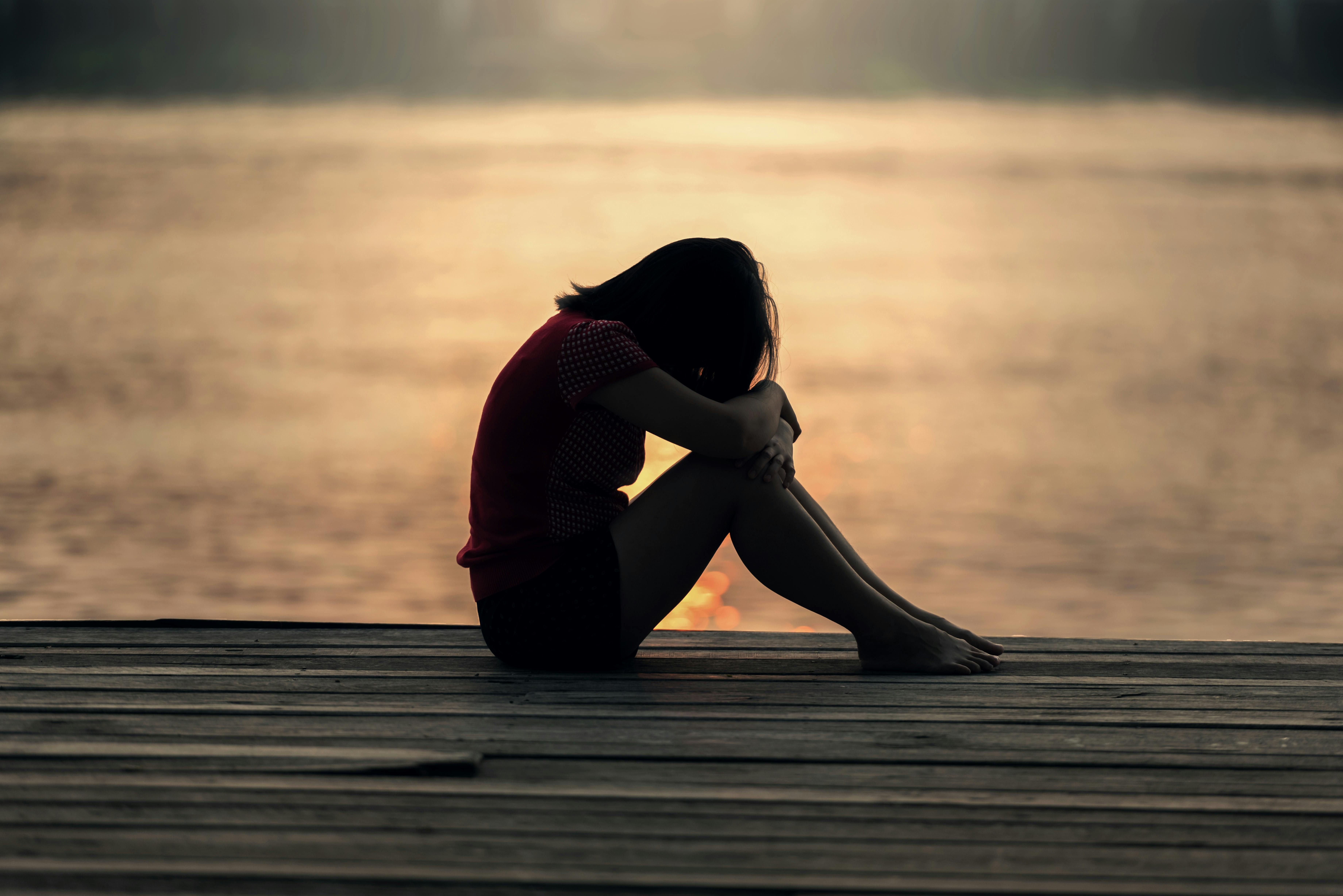 Person-sitting-on-beach-struggling-with-college-mental-health-and-moodswings